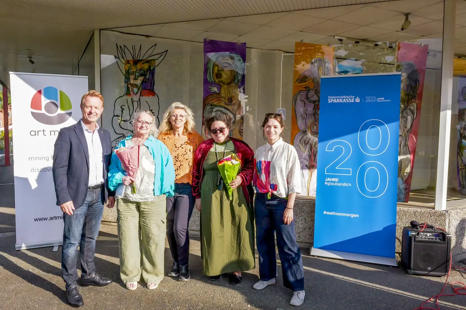 Kunst im Trofaiacher Schaufenster Ein Mann und vier Frauen vor einem Schaufenster mit Gemälden darin