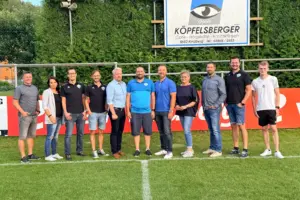 Neuer Name und neuer Obmann bei den Kindberger Fußballern Elf Personen stehen auf einem Fußballfeld.