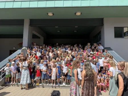 „Kleine Hände – große Kunst“ Eine große Gruppe an Schulkindern nimmt auf einer Treppe Aufstellung.