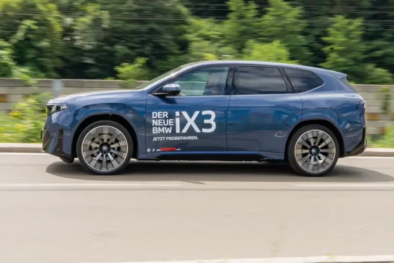 Mia san mia 4.0 Ein blauer Pkw der Karosserieform SUV fährt auf einer Straße von rechts nach links