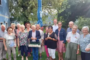 Eine Gruppe von älteren Menschen steht mit Geschenken auf einer Wiese