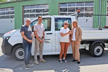 Neue Elektro-Pritsche im Brucker Fuhrpark Zwei Männer und zwei Frauen vor einem weißen Lieferwagen mit offener Ladefläche