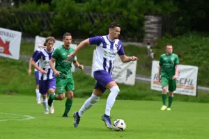 Ein Spieler in weiss-violett im Ballbesitz.