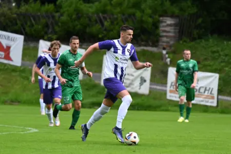 Ein Spieler in weiss-violett im Ballbesitz.