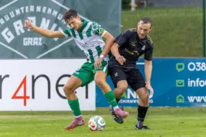 Zwei Fußballer kämpfen um den Ball.