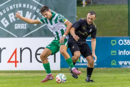 Zwei Fußballer kämpfen um den Ball.