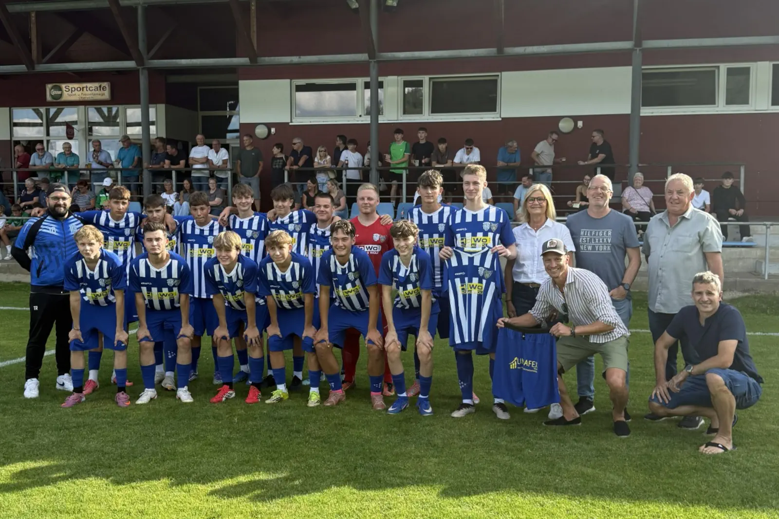 Eine Fußballmannschaft, dahinter einige Zuseher.