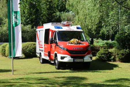 Frühschoppen mit Fahrzeugsegnung in Neuberg Ein mit Blumen geschmücktes Feuerwehrauto steht auf einer Wiese