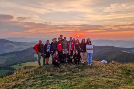 Gasen: Eine Expedition durch den Heimatort Eine Gruppe Jugendliche bei Sonnenaufgang auf einem Berggipfel