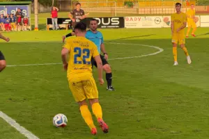 Ein Fußballer mit der Nummer 22. Dahinter ein Schiedsrichter.