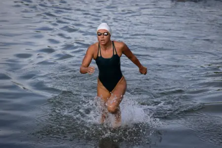 Mürztalerin trumpft im Rettungsschwimmen auf Eine Frau mit Badehaube, Schwimmbrille und Sportschwimmanzug läuft in knapp knietiefem Wasser