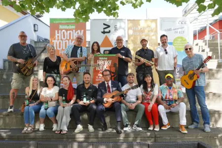 Die lange Nacht der Livemusik in Kapfenberg Eine große Gruppe von Personen posiert mit Musikinstrumenten und einem Plakat auf einer Treppe im Freien