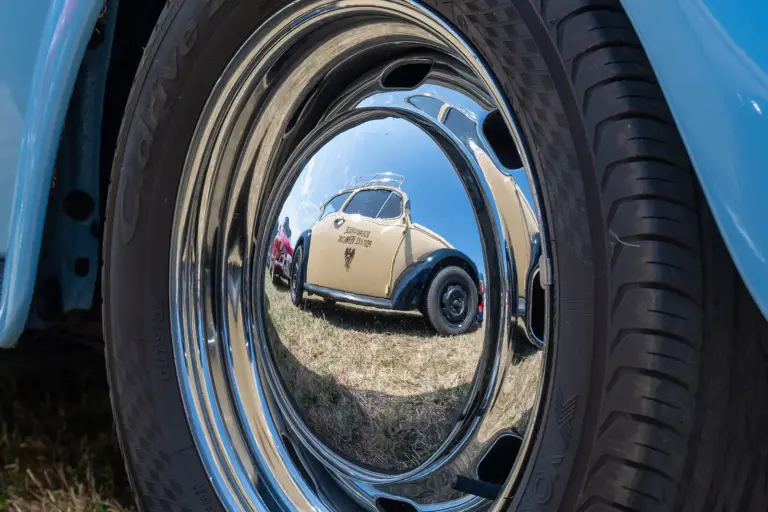 Oldtimertreffen in Parschlug – Fotogalerie II Ein Oldtimer-Auto spiegelt sich in der glänzenden Radkappe eines anderen Fahrzeugs
