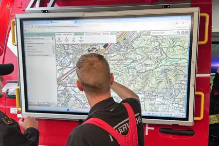 Einsatzübung mit Drohne in Kindberg Ein Mann in Feuerwehrkleidung steht vor einem großen Bildschirm