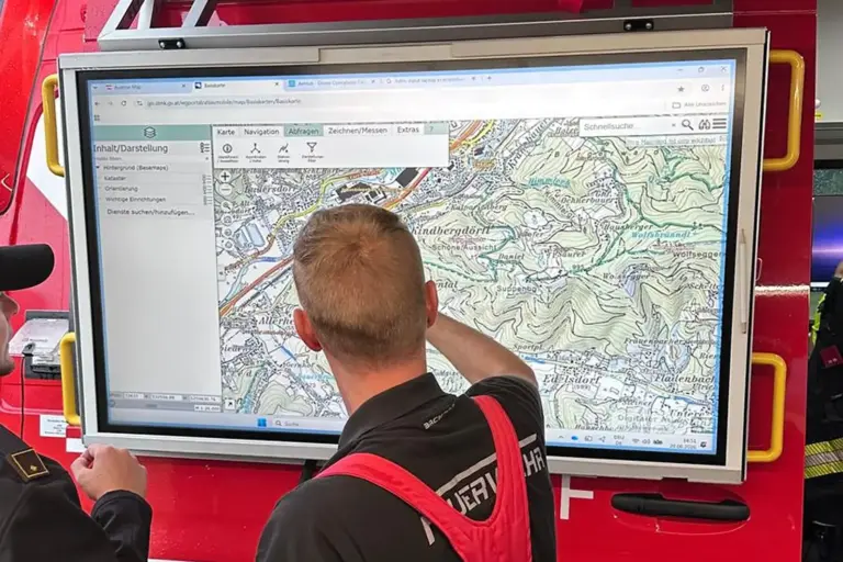 Einsatzübung mit Drohne in Kindberg Ein Mann in Feuerwehrkleidung steht vor einem großen Bildschirm