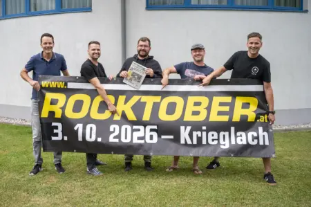 Rundschau ist Medienpartner für Rocktober in Krieglach Fünf Männer stehen mit einem Transparent auf einer Wiese