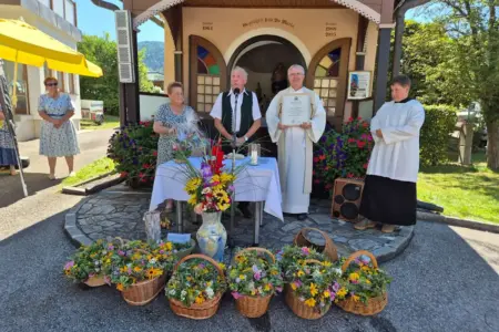 Mürzzuschlag: Ehrung für Hans Kandlbauer Ein Mann und eine Frau stehen mit einem Geistlichen und einem Meßdiener vor einer blumengesschmückten Kapelle