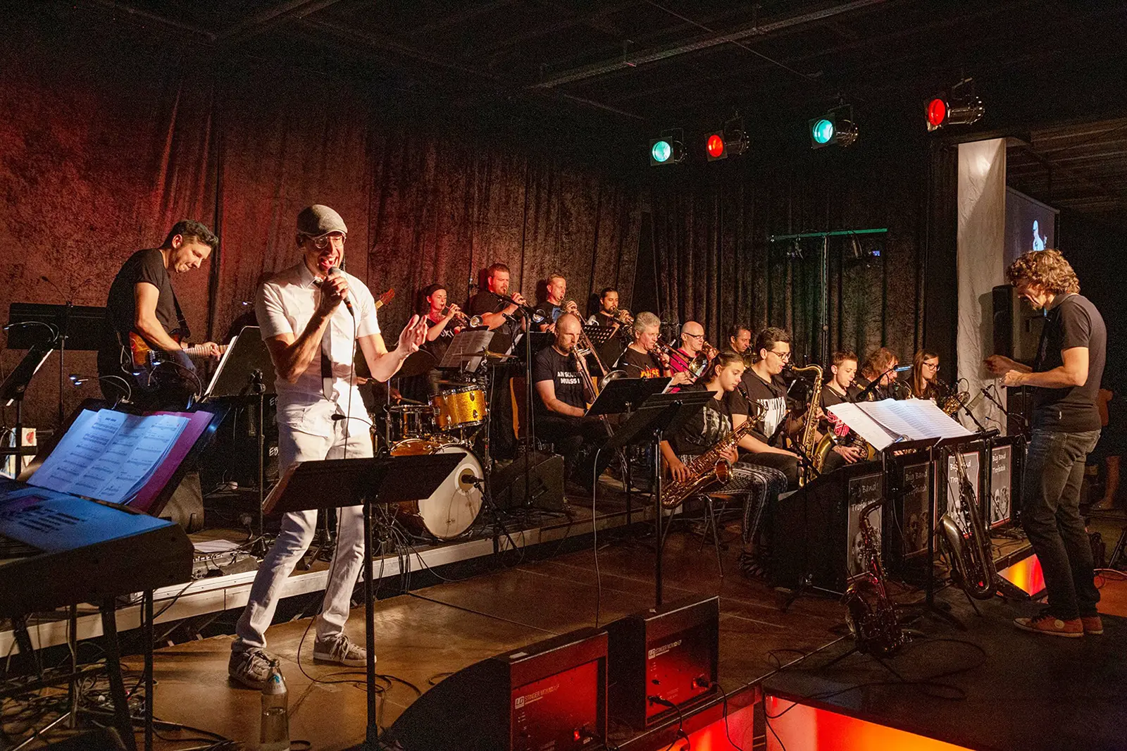 Eine Gruppe von Musikern mit Sänger spielt auf einer Bühne