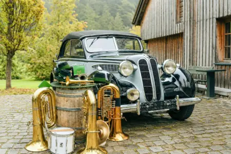 Oldtimer und Blasmusik in Turnau Mehrere Blasmusikinstumente stehen vor einem alten Auto