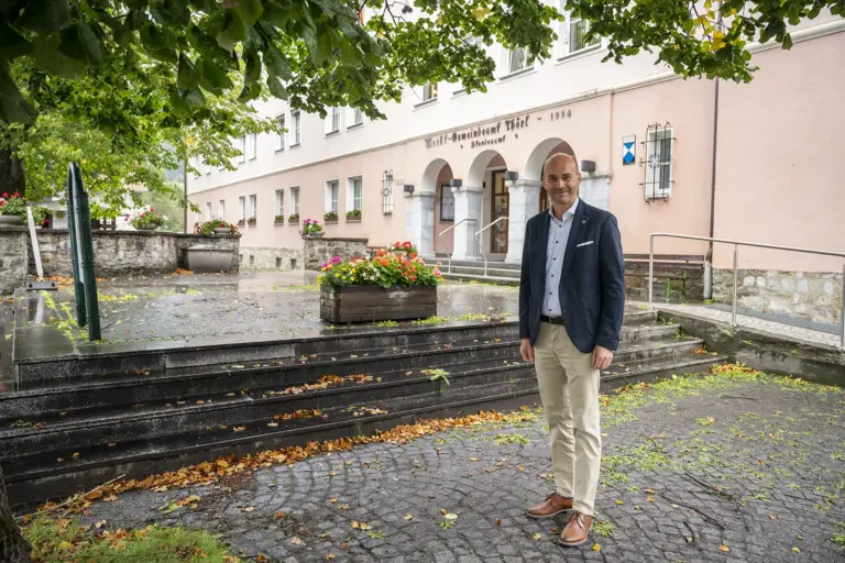 Gemeindeamt Thörl erhält einen neuen Vorplatz Ein Mann steht vor dem Marktgemeindeamt Thörl. Das rosafarbene Gebäude mit Rundbögen im Eingangsbereich ist von Bäumen und Blumenschmuck umgeben.