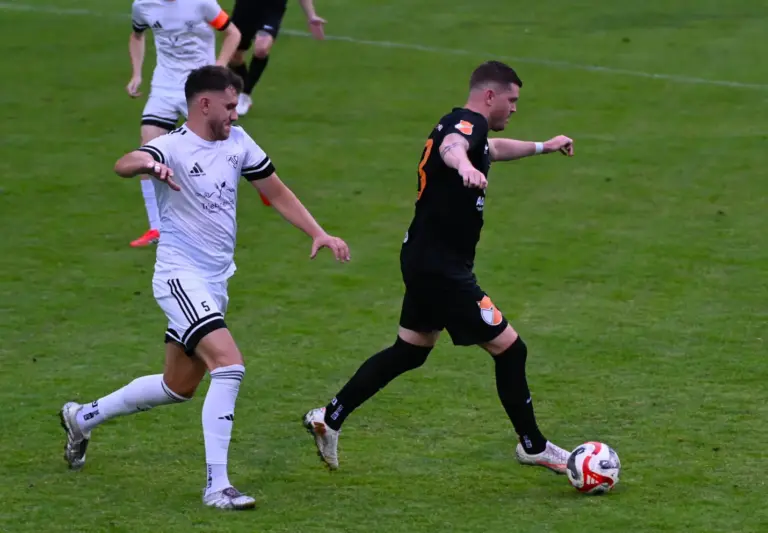 Der Aufsteiger lacht von der Tabellenspitze Der Spieler in schwarz läuft mit dem Ball.