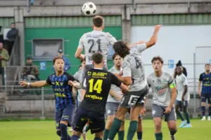 Zwei Fußballmannschaften beim Kopfballduell.
