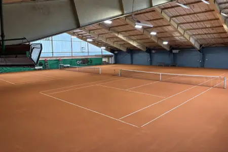 Eine Tennishalle mit zwei Plätze von oben.