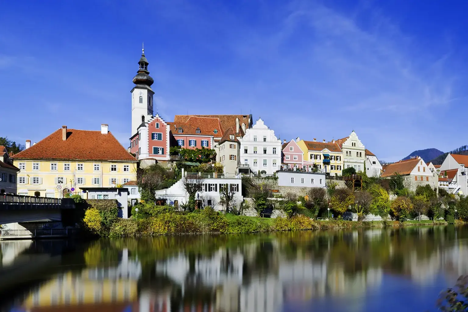 Frohnleiten feiert Geburtstag Die Silhouette einer Stadt spiegelt sich in einem Fluss