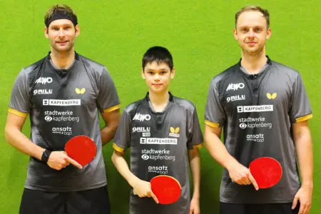 KSV-Tischtennis ist Tabellenführer Drei Tischtennisspieler in einheitlichen grauen Trikots stehen mit ihren Schlägern vor einer grünen Wand.