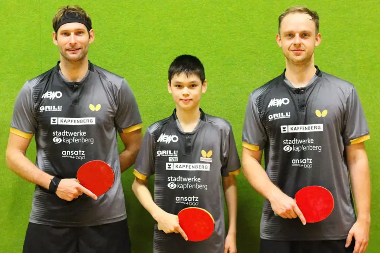 KSV-Tischtennis ist Tabellenführer Drei Tischtennisspieler in einheitlichen grauen Trikots stehen mit ihren Schlägern vor einer grünen Wand.