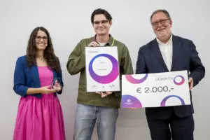 Zwei Männer und eine Frau mit einer Urkunde und einem Gewinnscheck