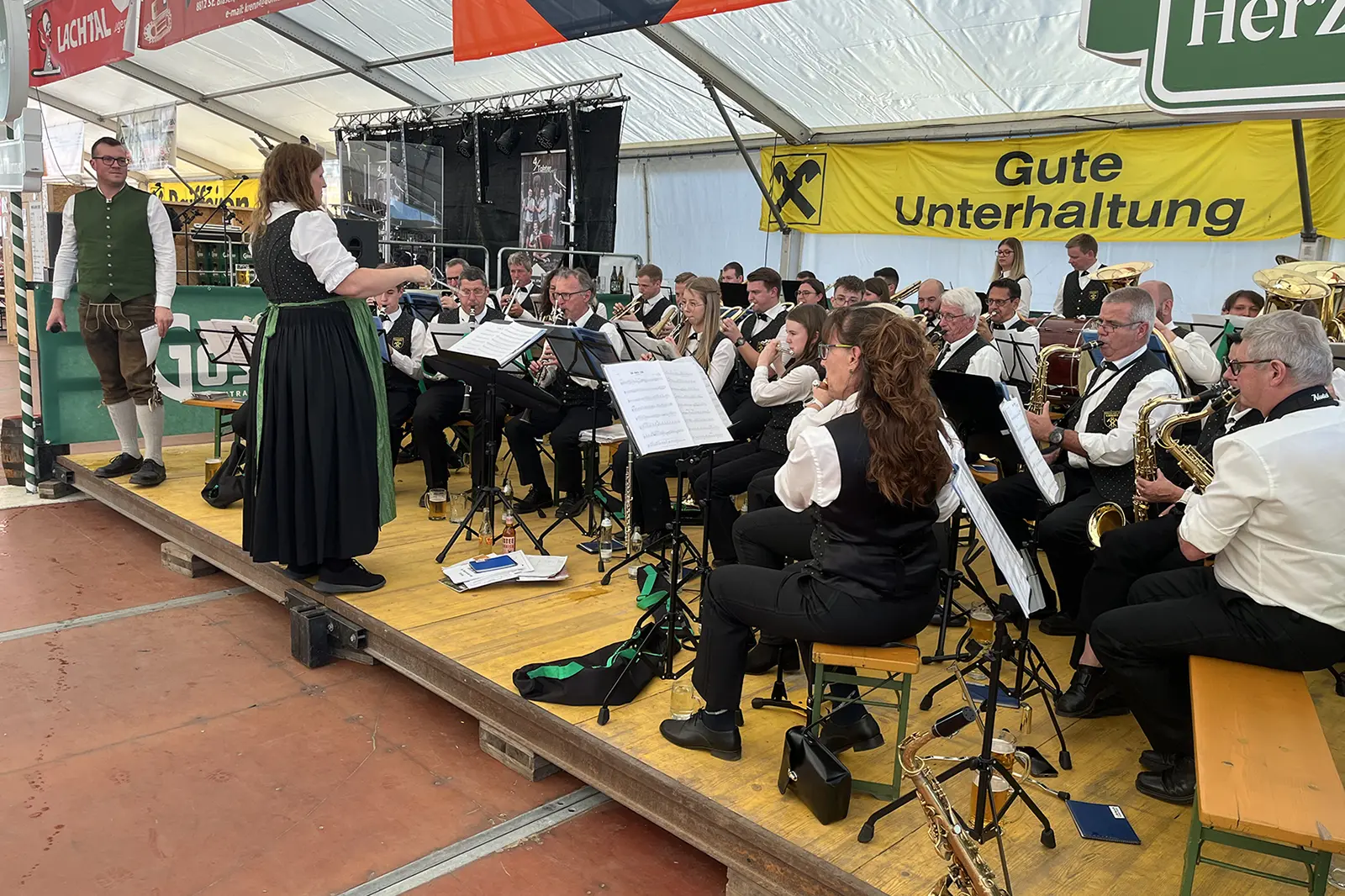 Eine Musikkapelle spielt auf einer Bühne in einem Festzelt
