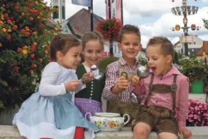 Kindberger Suppenstraße feiert 10-Jahr-Jubiläum Vier Kinder in Trachtenkleidung essen im Freien aus einem gemeinsamen Suppentopf