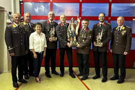 Feuerwehr Kindbergdörfl ist offiziell bei der Feuerwehr Kindberg-Stadt eingegliedert Mehrere Männer in Uniform und eine Frau in Zivilkleidung mit einer Statuette