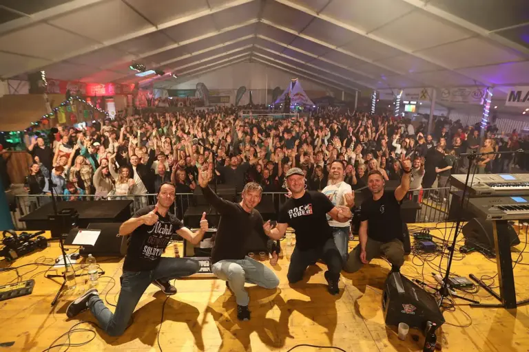 Krieglach: „Rocktober“ geht in die 26. Runde Fünf Männer posieren auf einer Bühne vor vielen Zuschauern