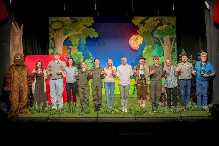 Gelungene Theaterpremiere in Leoben Eine Gruppe von Personen steht in Kostümen auf einer Theaterbühne