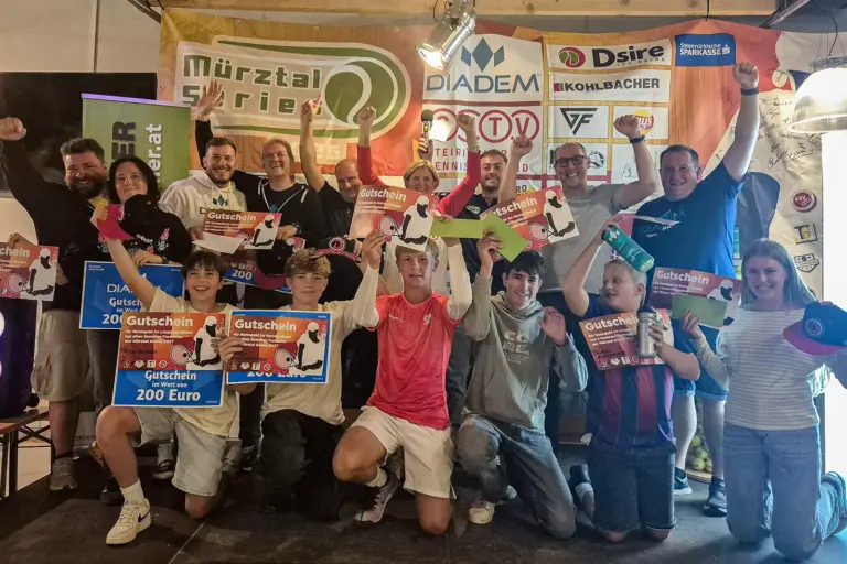 Gesamtsieger der Mürztal Series 2026 gekürt Eine Gruppe von Kindern, Jugendlichen und Erwachsenen feiert gemeinsam bei einer Siegerehrung. Mehrere Teilnehmer halten Gutscheine und Preise in die Höhe.