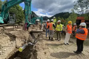 Eine Baustelle, an der mehrere Personen eine Leitung verlegen