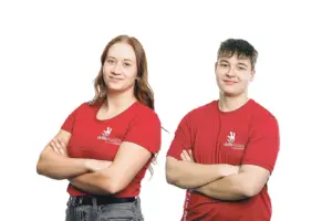 Ein Mädchen und ein junger Bursche in roten T-Shirts mit verschränkten Armen