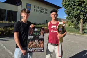 Zwei Männer stehen mit einem Kampfsportgürtel und einem Plakat vor einem großen Gebäude