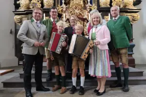 Fünf Erwachsene und zwei Kinder mit Ziehharmonikas stehen in einer Kirche