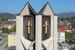 Ein Kirchturm vor einer Häusergruppe