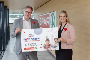 Ein Mann und einen Frau mit einem großen Spendenscheck