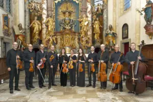 Ein Streichorchester steht vor einem Altar in einer Kirche