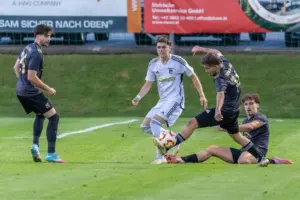 Vier Fußballer kämpfen um den Ball.