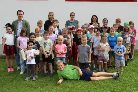 Abschluss des Turnauer Feriensommers Eine Gruppe von Kindern steht mit mehreren Erwachsenen auf einer Wiese