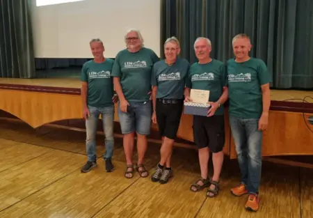 Erfolgreicher Spendenabend in Kindberg Fünf Männer in gleichen T-Shirts stehen vor einer Bühne