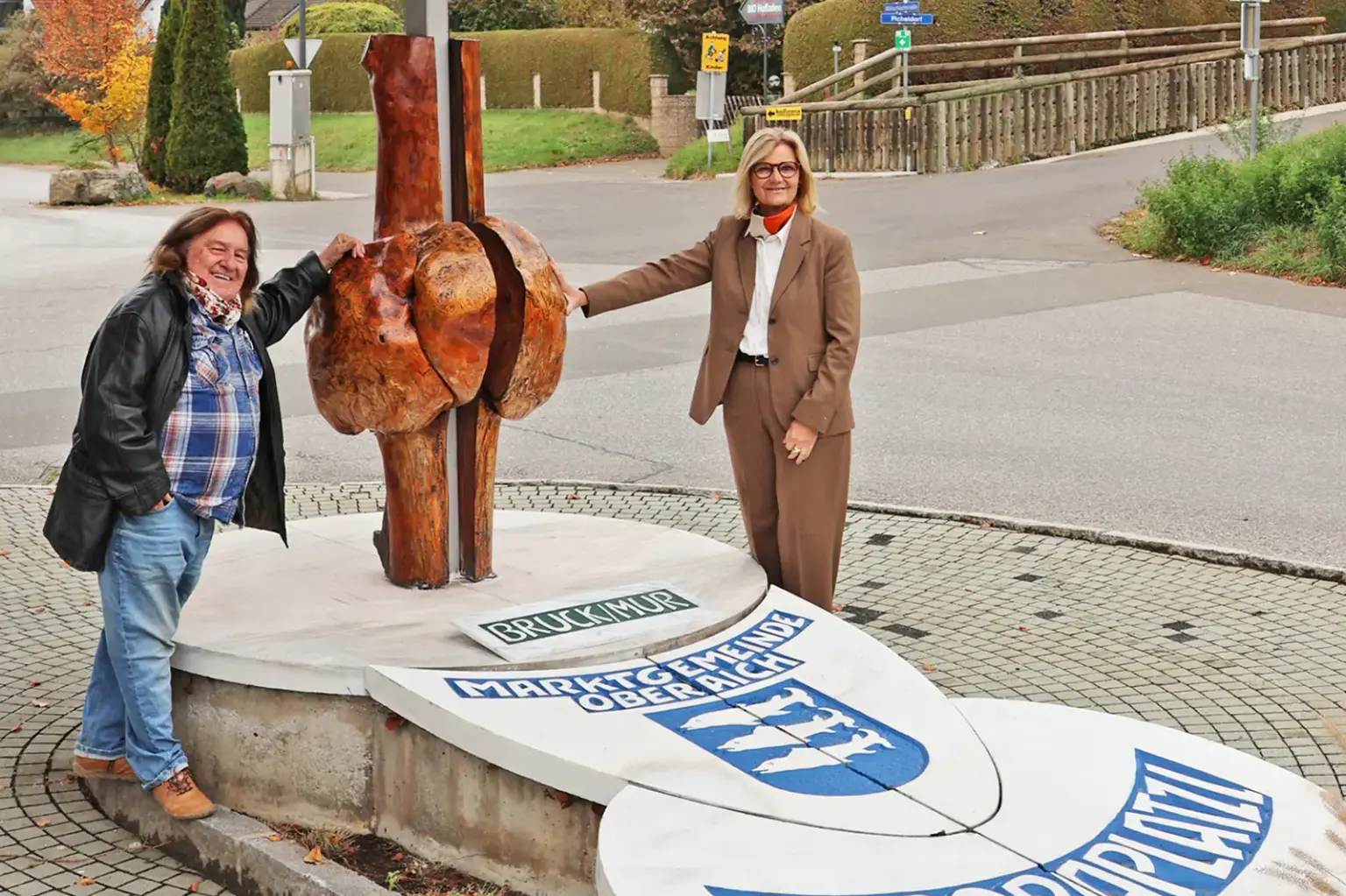 Brucker Kunstwerk in neuem Glanz Ein Mann und eine Frau stehen auf einem gepflasterten Platz neben einer Skulptur