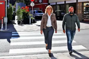 Ein Mann und eine Frau gehen über einen Zebrastreifen