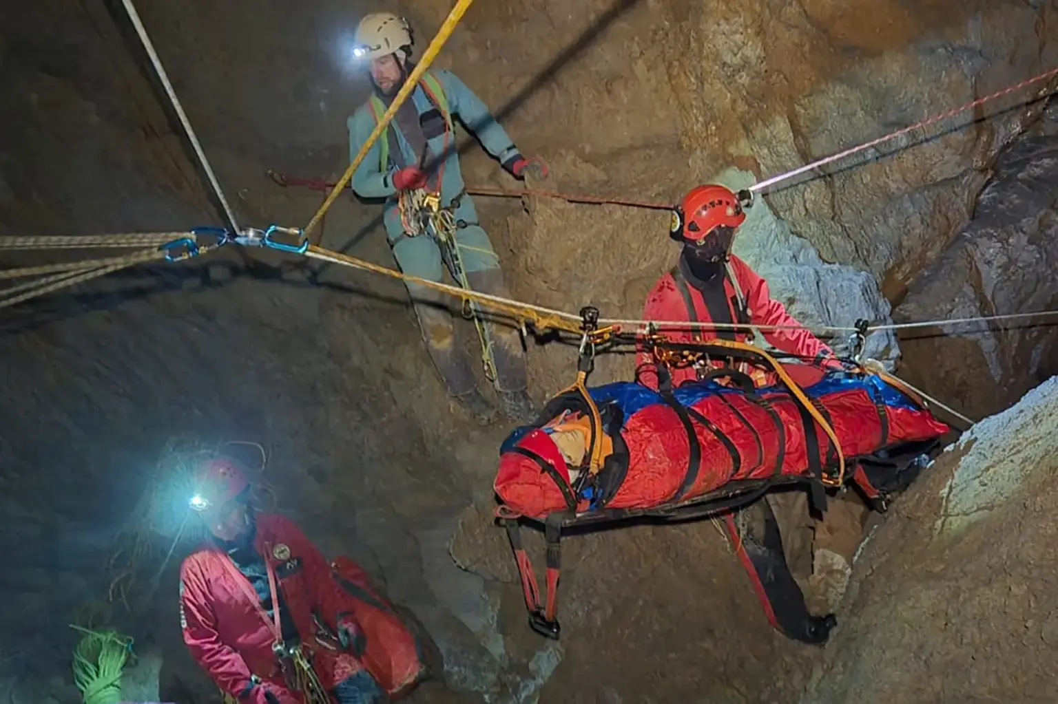 Herbstkurs der Höhlenrettung Eine Person auf einer Trage wird von mehreren Rettern in einer Höhle über eine Seilbahn abtransportiert